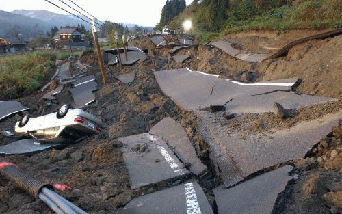 TOKIO â€“ Een omgeslagen auto in de provincie Niigata langs de kant van wat een asfaltweg is geweest, is een stille getuige van de aardbeving die Japan zaterdag opnieuw heeft getroffen. Tot nu toe zijn bij verschillende bevingen ten minste 24 mensen om he