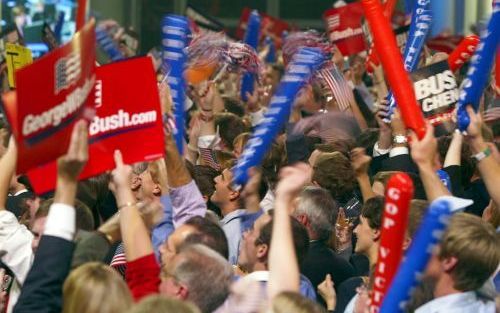 WASHINGTON â€“ Aanhangers van president George W. Bush juichen hem toe als zij de verkiezingsresultaten volgen op een televisiescherm in het Ronald Reagan Centrum in de Amerikaanse hoofdstad Washington. Foto EPA