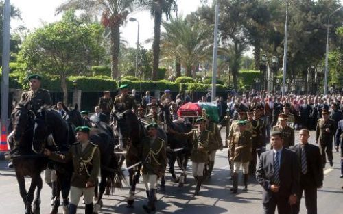 RAMALLAH - De kist van de overleden Palestijnse leider Yasser Arafat op een koets, voordat hij vrijdag begraven werd. De Palestijnse vlag is over de kist gelegd. Foto EPA