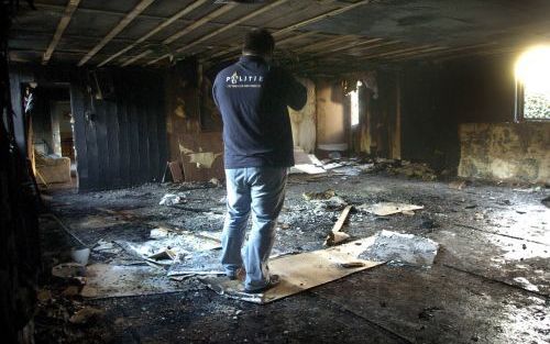 HELDEN â€“ Een politieman bekijkt de schade in de houten moskee van Helden. De Limburgse moskee brandde zaterdagmorgen geheel uit. Niemand raakte gewond. De brand is waarschijnlijk aangestoken, zo maakte justitie bekend. Foto ANP