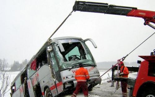 SEEWALCHEN - Reddingsmedewerkers proberen de omgekiepte bus weer naar boven te halen. Bij het ongeval kwam een vrouw om het leven.