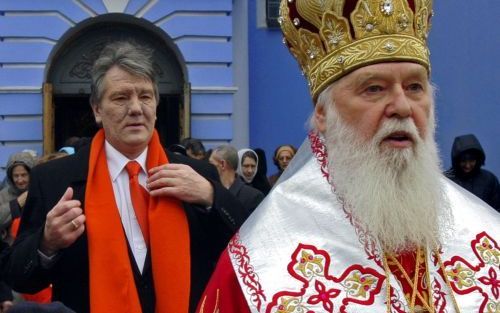 KIEV â€“ De OekraÃ¯ense premier en presidentskandidaat Viktor Janoekovitsj loopt achter patriarch Filaret â€“hoofd van het Kievse patriarchaat van de OekraÃ¯ens orthodoxe kerkâ€“ aan als zij zich naar de kerk begeven. Zondag gingen de inwoners van OekraÃ¯