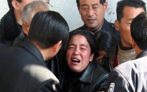 TONGCHUAN - Familieleden van de mijnwerkers wachten vol spanning op nieuws van overlevenden. Foto EPA