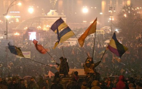 KIEV â€“ Aanhangers van de OekraÃ¯ense oppositieleider en presidentskandidaat Viktor Joestsjenko zwaaien uitbundig met vlaggen tijdens de protestbijeenkomst op het Onafhankelijkheidsplein in Kiev. De crisis in OekraÃ¯ne die vorige week na de tweede ronde 