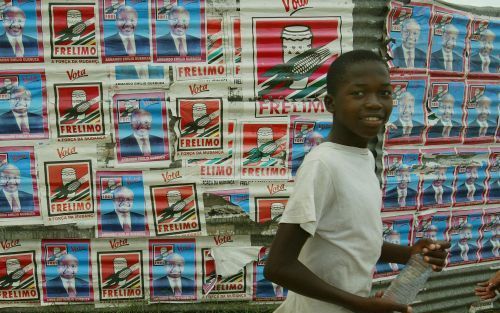 MAPUTO â€“ Een Mozambikaans jongetje loopt langs een muur die volgeplakt is met verkiezingsposters. Woensdag en donderdag gaan de inwoners van het Zuid Afrikaanse land naar de stembus om een nieuw parlement en een nieuwe president te kiezen. Foto EPA