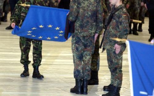 SARAJEVO - De Britse generaal David Leakey rolt de EU-vlag uit tijdens de overdrachte van het commande in BosniÃ«. De EU neemt het bevel van de vredes missie over van de Navo. Foto: EPA