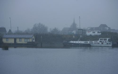 GOUDERAK â€“ Mist stijgt op van de Hollandsche IJssel en verhult het kale terrein van de voormalige Zellingwijk in Gouderak. De wijk is ruim twintig jaar geleden ontruimd en afgebroken omdat er gif was gevonden. De woonboten op de voorgrond moeten verkass