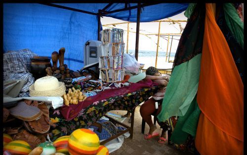 WILLEMSTAD â€“ Markt langs de Annabaai in hartje Willemstad. Bij gebrek aan toeristen doet de verkoper van kleurrijke kleden een dutje. Foto RD, Henk Visscher