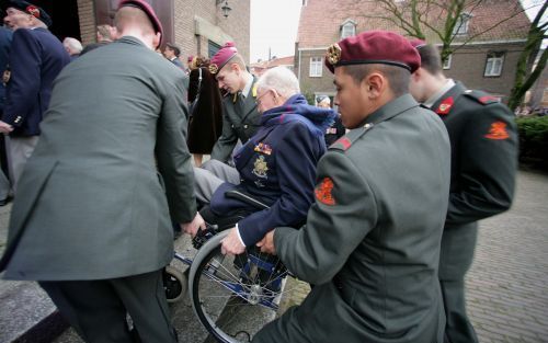 WAGENINGEN â€“ Een veteraan wordt met zijn rolstoel de Johannes de Doperkerk in Wageningen binnengedragen. In aanwezigheid van mr. Pieter van Vollenhoven en diverse militaire prominenten uit binnen- en buitenland, is donderdag in de kerk een besloten herd