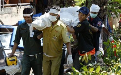 PATONG- Thaise reddingswerkers dragen het lichaam weg van een toerist die onder het puin gevonden werd in Patong Beach. Er zijn al honderden lichamen gevonden, sinds de Thaise reddingswerkers de puinhopen zijn gaan onderzoeken. Foto EPA.