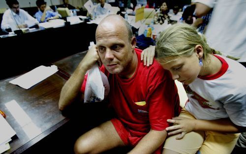 PHUKET â€“ Patrick van der Herberg zit met zijn dochtertje in het stadhuis van Phuket. Een andere dochter en de moeder van het gezin zijn eveneens in leven, maar verblijven na redding op een ander eiland. Foto ANP