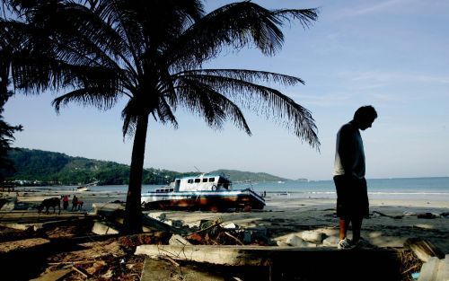 PATONG BEACH â€“ Een toerist bekijkt de schade op het strand van Patong Beach in de Thaise provincie Phuket. Foto ANP