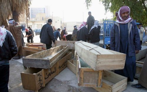 BAGDAD â€“ Kisten staan klaar als de lichamen van achttien Irakezen per vrachtwagen worden afgeleverd bij het mortuarium. De achttien werden in de omgeving van Mosul omgebracht. Ze waren naar het noorden gelokt met een aantrekkelijke aanbieding voor werk.