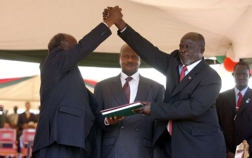 NAIROBI â€“ De president van Kenia, Mwai Kibaki (l.), drukt de hand van de leider van de Sudanese rebellenbeweging SPLA, John Garang, terwijl de Ugandese president Joweri Museveni toekijkt. De regering van Sudan en de SPLA tekenden zondag een vredesakkoor