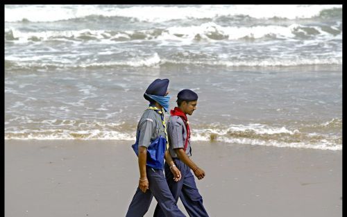 Hulpverleners lopen langs het strand van Tranquebar, op zoek naar slachtoffers van de vloedgolf. Foto Henk Visscher