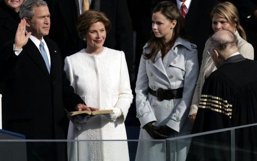 WASHINGTON â€“ De Amerikaanse president Bush legt de presidentiÃ«le eed af onder het toeziend oog van de voorzitter van het Hooggerechtshof, William Rehnquist (r.). Bush’ vrouw Laura en dochters Barbara en Jenna (vlnr) kijken toe. Foto EPA