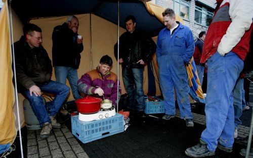 ZOETERMEER - Actievoerende boeren eten maandagochtend een kopje erwtensoep voor het gebouw van het productschap Tuinbouw in Zoetermeer. Enkele tientallen boeren blokkeren vanaf ongeveer 7 uur de ingang van het gebouw met tractoren en andere landbouwmachin