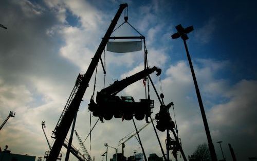 NIEUWKOOP - Een hijsinstallatie van bergingsbedrijf Mammoet tilde maandagmorgen een kraan uit een moddersloot in het Nieuwkoopse plassengebied. Het 13.000 kilo wegende gevaarte raakte een maand geleden te water toen het van een veeboot af wilde rijden. De