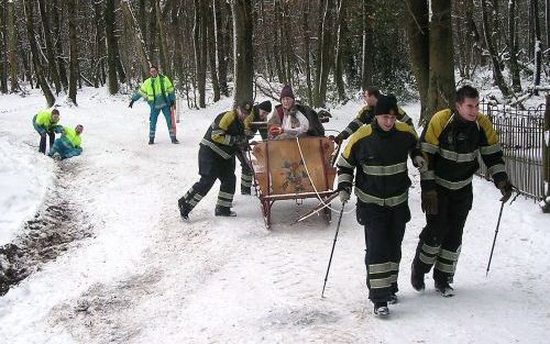 Medewerkers van ambulancedienst en brandweer hebben dinsdagmiddag een gewonde hartpatiÃ«nt per arrenslee over de besneeuwde heuvels van het Vijlenerbos in Zuid-Limburg naar de ambulance gebracht. Foto ANP