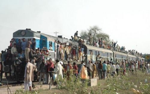 ALLAHABAD - Naar schatting heeft India in 2030 de meeste inwoners ter wereld. Foto: Gelovigen nemen de trein na een bezoek aan de heilige rivieren, de Ganges en de Yamuna.