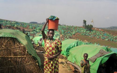 TCHE â€“ Een Congolese moeder wandelt met haar dochter door een vluchtelingenkamp in het noordoosten van Congo. Bij gevechten met de plaatselijke VN macht kwamen deze week enkele tientallen Congolese rebellen om het leven. - Foto EPA