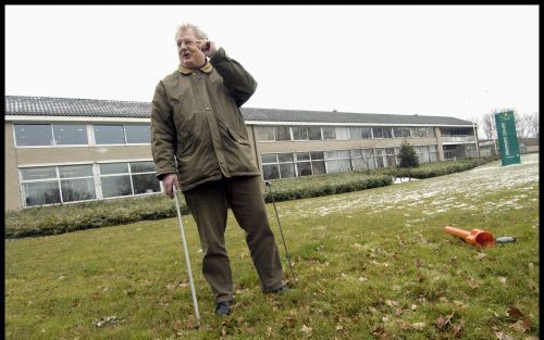 BARNEVELD â€“ Kees Janse, cursusleider mollenbestrijding, met prikstok en gaspistool op het gazon voor het Groenhorst College in Barneveld. AgrariÃ«rs, loonwerkers en ongediertebestrijders van provincies en gemeenten bevolken doorgaans de cursus. Ook ”gre