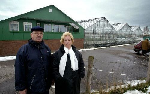 ROELOFARENDSVEEN - Het echtpaar Jong voor hun potplantenkwekerij. In de schuur is het balkon te zien van de woning, die illegaal boven de waterbassins is gebouwd. De gemeente Alkemade gedoogt dat niet en wil dat het echtpaar verhuist. Foto RD, Henk Vissch