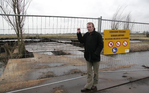 GOUDA - Raadslid W. Westendorp voor het hek rond de vervuilde grond aan de Tweede Moordrechtse Tiendeweg in Gouda. De SP’er vindt dat het veel te lang heeft geduurd voordat de gemeente actie ondernam. Foto Martin Droog