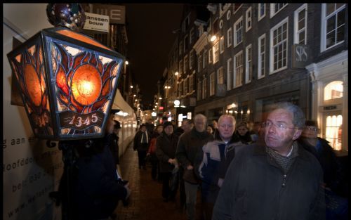 AMSTERDAM â€“ Deelnemers aan de Stille Omgang, die in de nacht van zaterdag op zondag in de Amsterdamse binnenstad werd gehouden, passeren in de Kalverstraat de plaats waar in 1345 een mirakel zou zijn gebeurd. Een man zou hier een hostie hebben uitgebraa