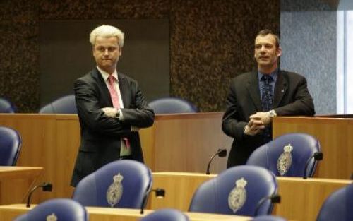 DEN HAAG - Geert Wilders (links) dinsdag met een van zijn beveligingsmensen tijdens het vragenuurtje in de Tweede Kamer. Politiek Den Haag reageert terughoudend op het beginselprogramma van Wilders. FOTO ANP