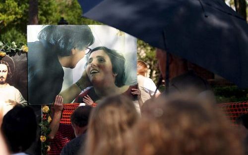 FLORIDA - Steunbetuigers van de ouders van Terri Schiavo houden een foto van haar vast bij het Woodside ziekenhuis in Florida. EPA