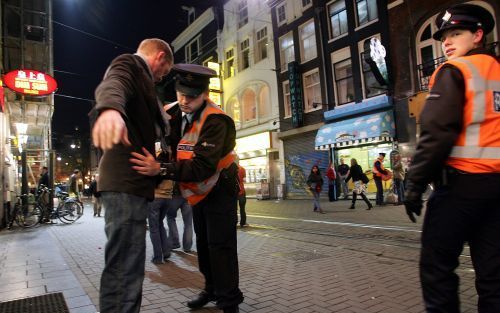 AMSTERDAM - Een man wordt donderdagavond preventief gefouilleerd in de Leidsestraat in Amsterdam. De politie in Amsterdam is donderdagmiddag begonnen met een grootscheepse controle in de binnenstad. Foto ANP