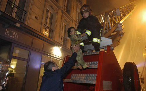 PARIJS â€“ Een brandweerman slaagde er vrijdagochtend in tussen de waterstralen door een kind uit de vlammen van het hotel te redden. Het dodental bij de calamiteit in Parijs is opgelopen tot twintig, onder wie tien kinderen. In de Franse hoofdstad en bij