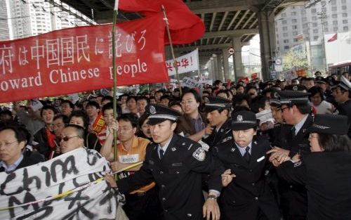 SJANGHAI â€“ Betogers in de Chinese stad Sjanghai doorbreken een politiekordon. Tienduizenden Chinezen liepen afgelopen zaterdag door de straten van de havenstad om te protesteren tegen een mogelijke permanente zetel voor Tokio in de Veiligheidsraad van d