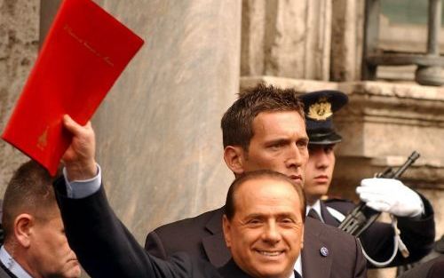 ROME â€“ De Italiaanse minister president Silvio Berlusconi groet journalisten bij het verlaten van de Senaat in Rome. Berlusconi kondigde gisteren aan af te treden en een nieuwe regering te vormen om zo de onenigheid binnen zijn coalitie op te lossen. - 