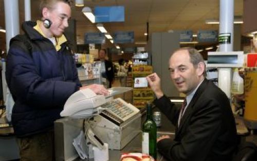 AMSTERDAM - De Amsterdamse burgemeester Cohen controleert een identiteitspas van een jongen die een fles wijn koopt. De burgemeester heeft maandagmiddag in de Albert Heijn het startschot gegeven van de landelijke campagne Leeftijdsgrenzen Alcoholverkoop 2