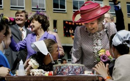 SCHEVENINGEN - Koningin Beatrix bekijkt tijdens haar wandeling door Scheveningen het knutselwerk van kinderen. Foto ANP