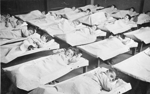 AMSTERDAM â€“ Joodse kinderen op veldbedden in de slaapzaal van een crÃ¨che in Amsterdam. Vanuit de crÃ¨che tegenover de Hollandsche Schouwburg ontsnapten 500 kinderen aan deportatie. Foto Joods Historisch Museum