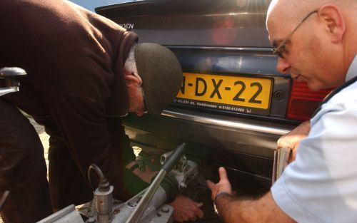 C. Heemskerk (r.) van de Verkeersongevallendienst bekijkt het remsysteem van een caravan tijdens een controle bij het Waddinxveense CampoWorld. Foto’s Bram Gebuys