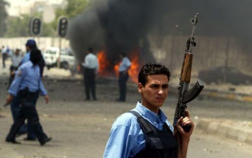 Een politieman op de plek waar de dader van een bomaanslag in Bagdad een autobom explodeerde.