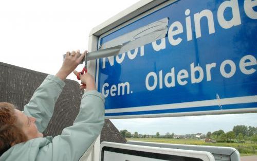 NOORDEINDE - Heidi Kroes uit Noordeinde plakt het plaatsnaambord van haar dorp gedeeltelijk af. Bewoners van het noordelijkste dorp van Gelderland vrezen dat plannen voor een nevengeul van de IJssel het einde betekenen van hun woonplaats.Â¶ fotoverantwoor