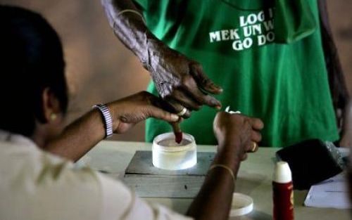 PARAMARIBO - Een inwoner van Suriname steekt zijn pink in rode inkt. De inkt is bedoeld als merkje voor het feit dat je gestemd hebt. Voor de Surinamers een stemformulier krijgen, moeten ze hun handen laten zien. De Surinamers gingen woensdag in Paramarib