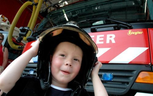 KAMPEN â€“ Een jongetje past een helm in de nieuwe brandweerkazerne van Kampen. De Kamper brandweer hield zaterdag open huis vanwege de ingebruikname van het nieuwe onderkomen aan de Jan Ligthartstraat. Foto RD