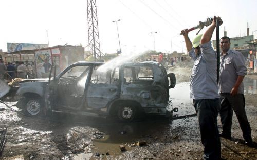 BAGDAD â€“ Brandweerlieden blussen een brandende politieauto in het zuiden van de Bagdad. Bij een aanslag op een politiepatrouille in de Iraakse hoofdstad kwamen gisteren zeven agenten om het leven en raakten negen anderen gewond. Foto EPA