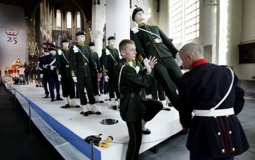 DEN HAAG â€“ Twee mannen plaatsen de laatste aangeklede pop in de stoet voor Prinsjesdag. De poppen en nagemaakte paarden en de echte gouden koets maken deel uit van de expositie ”Majesteit! 25 jaar koningin Beatrix!” De tentoonstelling is tot 21 augustus