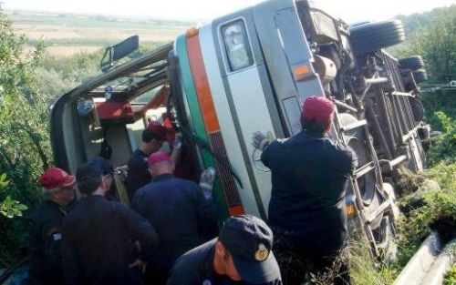 LAMIA (Griekenland) - Mensen van de plaatselijke hulpdiensten inspecteren een bus die zaterdag door een slippartij over de kop sloeg. Daarbij kwamen drie personen om het leven en raakten 37 mensen gewond. Foto EPA