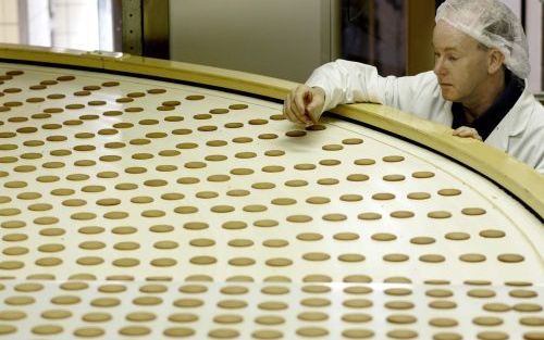 GOUDA â€“ Een medewerker controleert het productieproces van de Punselie stroopwafeltjes. Dinsdag gaf het bedrijf aandelen uit om het hoofd boven water te houden. Foto ANP