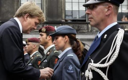 DEN HAAG - Kroonprins Willem Alexander spelt woensdag op het Binnenhof een herinnneringsmedaille op bij sergeant Hulsman-Dag van de Koninklijke Luchtmacht. Hulsman-Dag behoorde tot de acht veteranen die persoonlijk door de prins en minister Kamp (Defensie