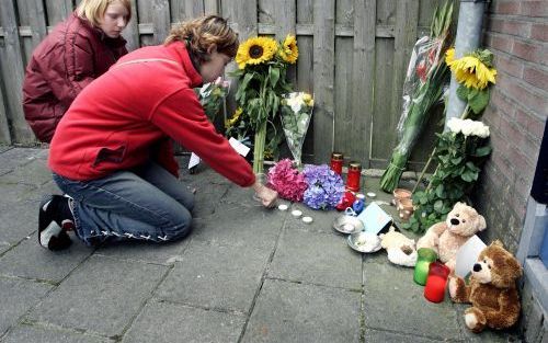 TOLBERT â€“ Bij het huis van de maandag vermoorde kinderen uit Tolbert werden dinsdag bloemen gelegd en kaarsjes aangestoken. Sommige mensen namen knuffels mee. Foto ANP.