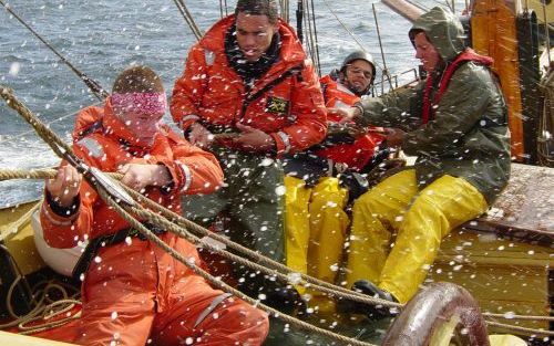 ENSCHEDE â€“ Jongeren doen hun best om zeilschip de Tukker in bedwang te houden. Op het schip uit 1912 varen al 25 jaar lang probleemjongeren mee, om te voorkomen dat ze „tussen wal en schip” belanden. Ze doen dat als onderdeel van een hulptraject om hun 